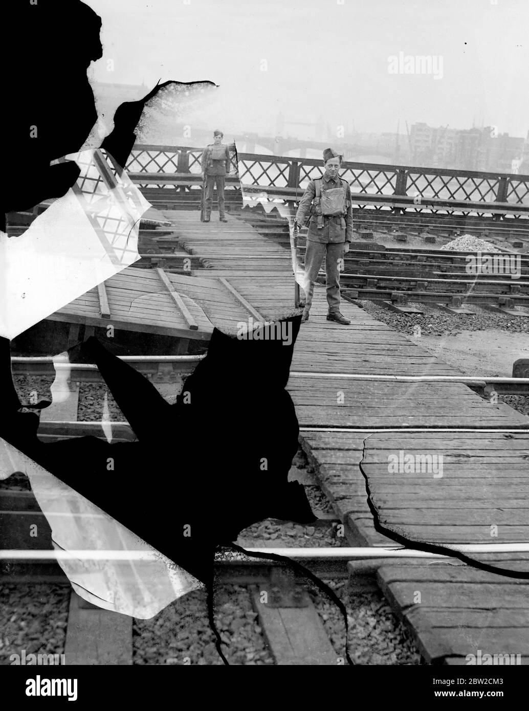 Military guards have been installed at vital points in London, including railway stations, goods yards and important municipal buildings. Military guard on a railway bridge across the Thames. 30 August 1939 Stock Photo