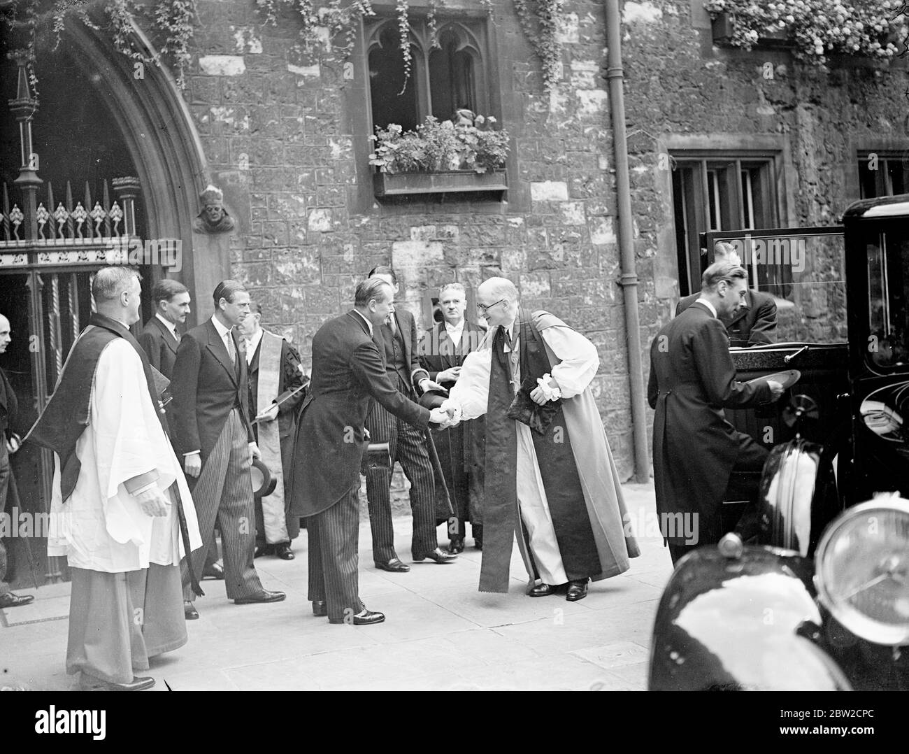 The King, with the Dukes of Gloucester and Kent, attended a special Mass for peace at Westminster Cathedral this morning (Sunday). The King and the Duke of Kent broke off their holidays to return to London because of the crisis. The King entering his car as the Duke of Gloucester shakes hands with the Rev Paul de Labilliere, Dean of Westminster. 27 August 1939 Stock Photo