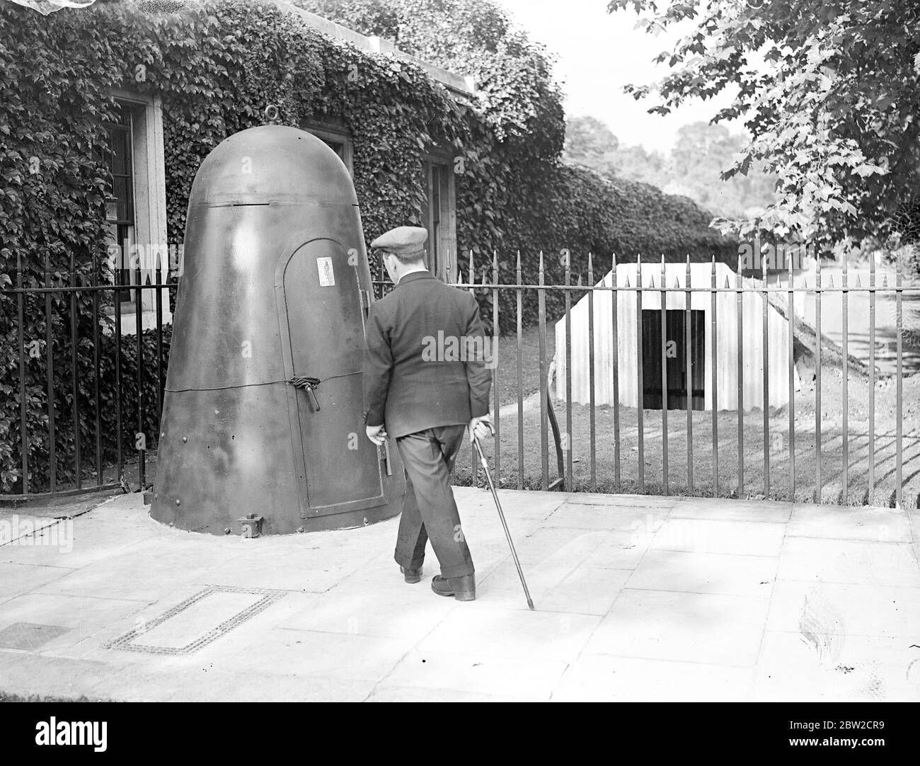 Air raid shelters are being constructed or placed in position at the Royal palaces in London. Special types of steel shelter - similar to those for the use of key men in air raids - have been placed in position for the sentries. Contrasting air shelters at the lodge gates of St James's Palace. The steel shelter is for the sentry. That on right is the Anderson type for householders. 29 August 1939 Stock Photo
