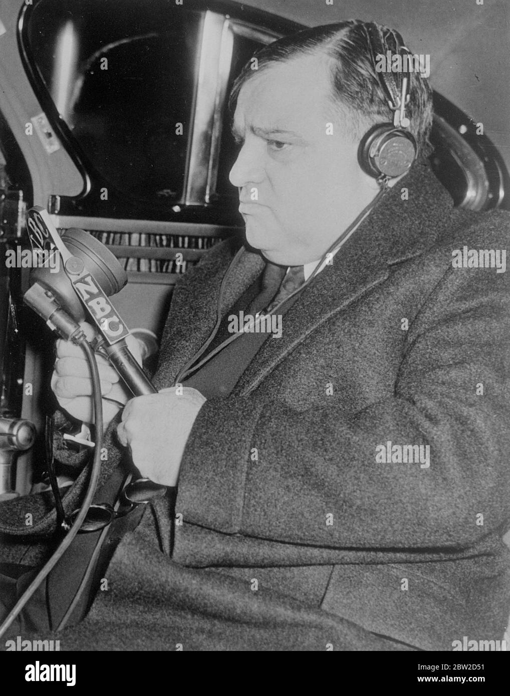 Riding to work in his car, Mayor Fiorello La Guardia of New York carried on a friendly chat with Lord Mayor of London, Sir Frank Bowater, who was speaking from his State coach outside the Mansion House. The two Chief Citizens discussed the weather, airports and the marvel of their carrying on such a conversation. Radio officials in New York said it was the first time a trans Atlantic conversation had been carried on by two persons in moving vehicles. Photos shows: Mayor Fiorello talking from his car in New York to the Lord Mayor of London. 4 February 1939 Stock Photo