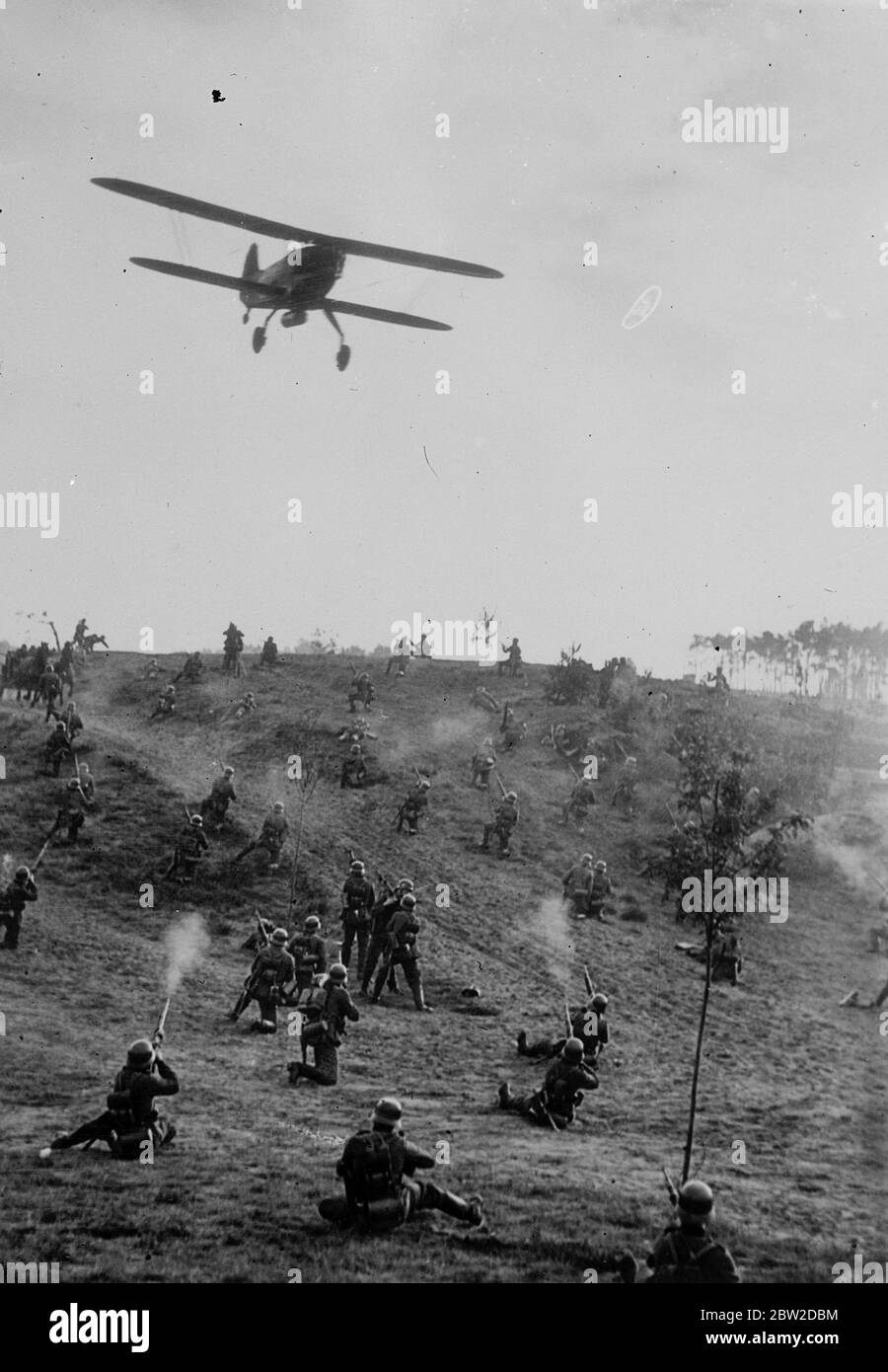 German warplanes, large number of troops and the Doberitz manoeuvre grounds were borrowed by the German UFS film company to stage spectacular battle scenes for a new film, Three NCOs which glorify the German army. Photo shows: The troops firing at attacking aircraft in the thrilling mimic battle for the film cameras. 19 October 1938 Stock Photo