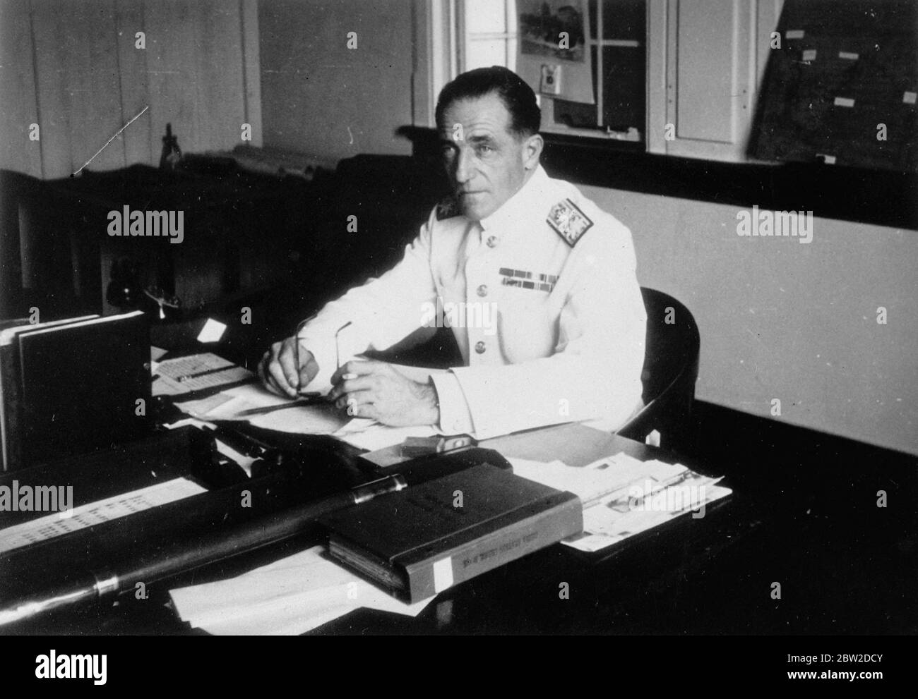Picture of rear Admiral R V Holt, commander-in-chief of the Yangtze Sea Gunboat Flotilla of the Royal Navy, at his temporary office in the Asiatic Petroleum Companies building on the Bund at Hankow, the provisional Chinese headquarters now threatened by the Japanese. 21 October 1938 Stock Photo