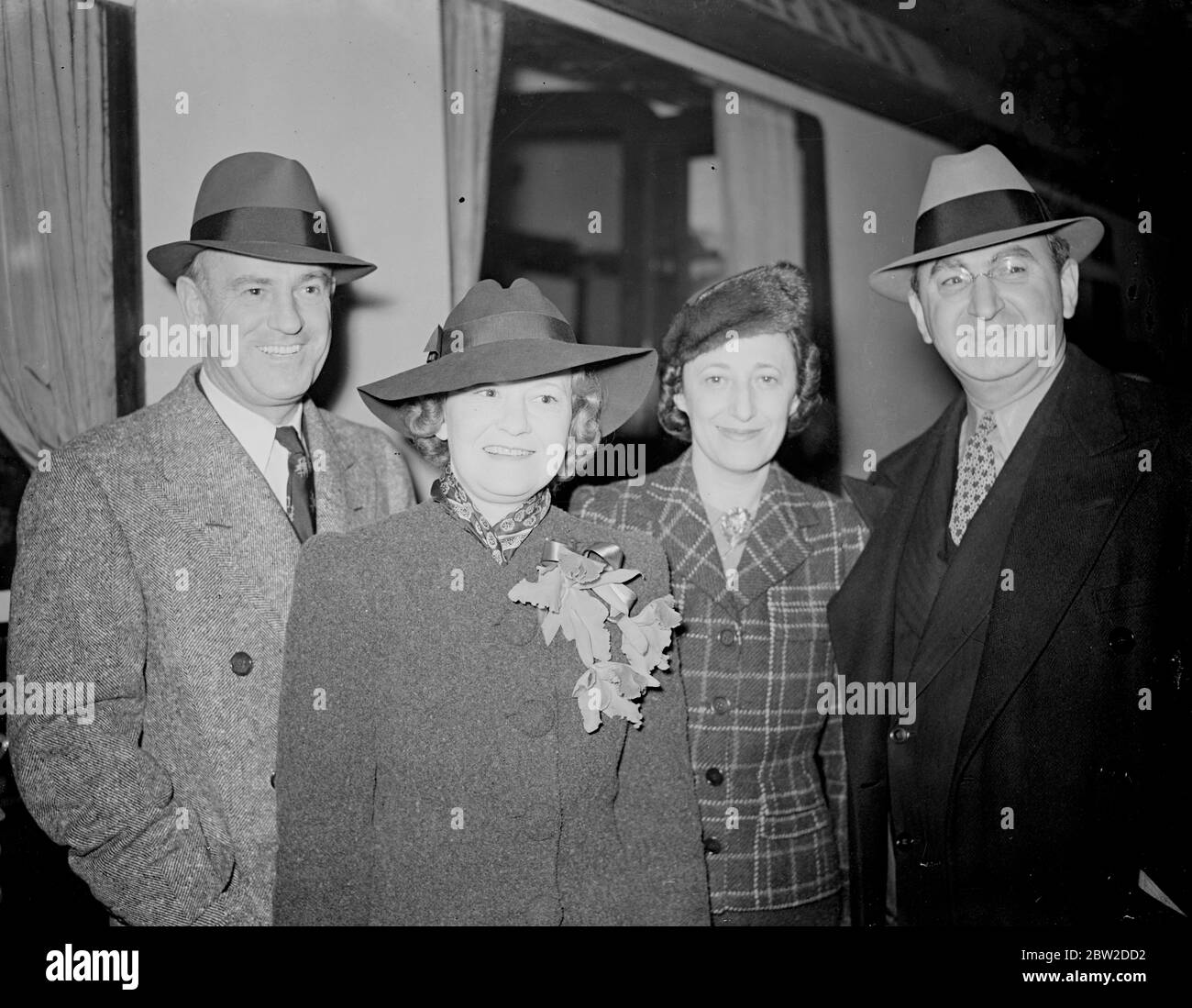 Mr Sam Wood, the Hollywood film director, arrived at Paddington station on the Queen Mary boat train to direct Robert Donat in Goodbye Mr Chips, a new British film. Mr Wood was greeted by Mr Ben Goetz, manager director of Metro-Goldwyn-Mayer British Studios. Photo shows: Left to right, Mr and Mrs Sam Wood with Mrs Goetz and Mr Ben Goetz, who welcomed them. 23 October 1938 Stock Photo