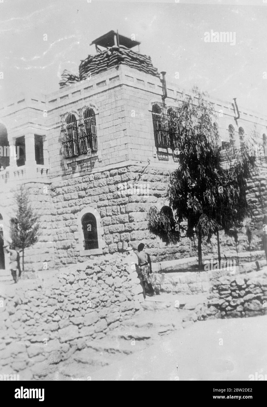 These pictures have just received from Palestine, where British troops are expected to begin the big offensive against the rebels of the Arab rebellion. Meanwhile, as a step towards martial law, military commanders have replaced civilian District Commissioners and the Palestine Police have been placed under military control. Photo shows The governor's residence at Hebron fortified against possible terrorist attacks. The buildings is protected by sandbags and sentinels which watch night and day. 19 October 1938 Stock Photo