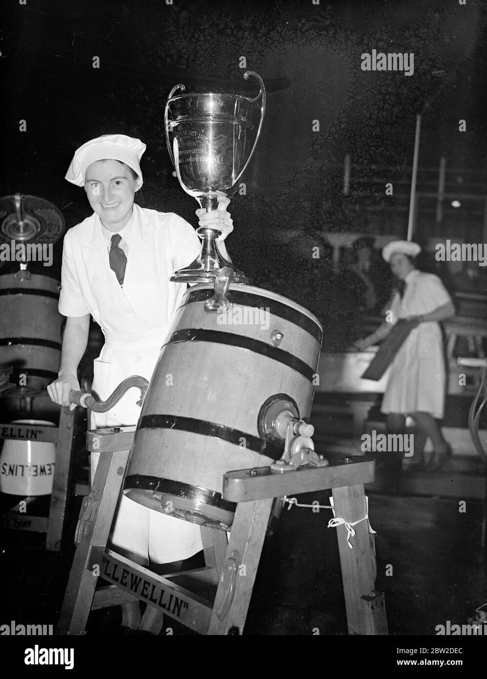 Mrs M R Mitchell of Tiverton, Devon, was judge champion butter maker at them dairy show now in progress at Olympia, London. Photo shows: Mrs M R Mitchell with the cup and her churn. 13 October 1938 Stock Photo