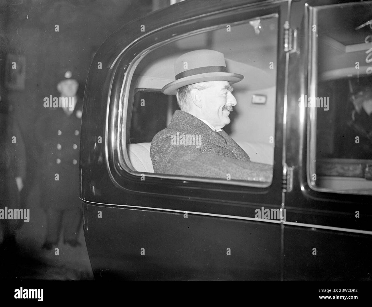 Mr Neville Chamberlain, the Prime Minister, travelled overnight from Scotland for the meeting of the Cabinet to review important matters such as the defence programme, the Anglo-Italian agreement, the situation in Palestine and legislation for the next session of Parliament. Photo shows: The Premier in his car at King's Cross station on his return to London. 19 October 1938 Stock Photo