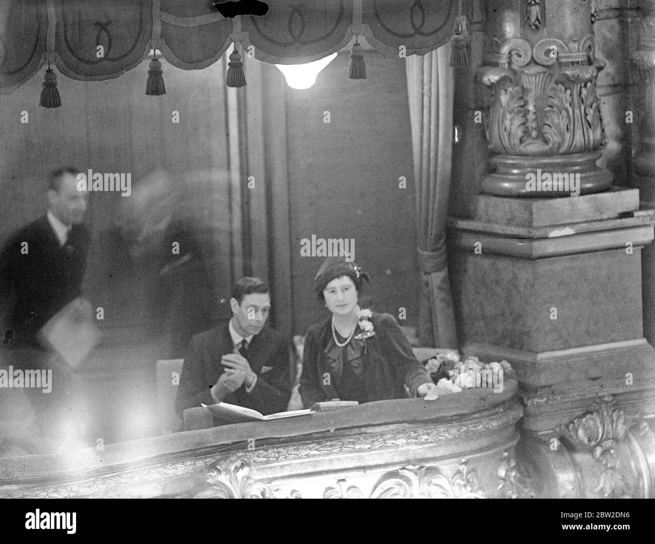 King and Queen at wounded ex-servicemen concert at Palladium. The King and Queen attended the Coronation Commemoration Concert for 3000 wounded ex-servicemen at the Palladium London. With them was Queen Ena (Victoria Eugenie of Spain). Photo shows, the King and Queen in the Royal box at the Palladium concert. 23 November 1937 Stock Photo
