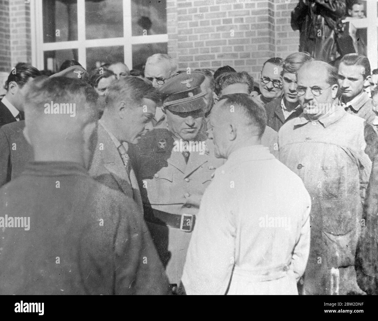 Making his first visit to the city in 13 years the Duke of Windsor was welcomed by the workers when he made his preliminary inspection of factories in by them, as quoted by German officials. The Duchess may man arrested at hotel the Duke of Windsor is to study housing and factory conditions and Germany before going to America on a similar mission. The Duke talking with a factory worker during his tour. 11 October 1937. Stock Photo