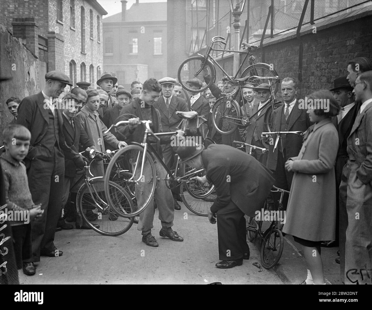 Showing off the merits of a Tandem machine in the cycle market in Sandford Road, Walworth. An old market that has been in existence in a little South London street almost since the advent of the bicycle is threatened by the authorities, this cycle market the only one in London once had its home in doors Street but has now been moved to Sandford Road familiarly known South Londoners as battling. The market is only held once a week on Sunday mornings and many machines valued from a few shillings to several pounds change hands. 10 October 1937. Stock Photo