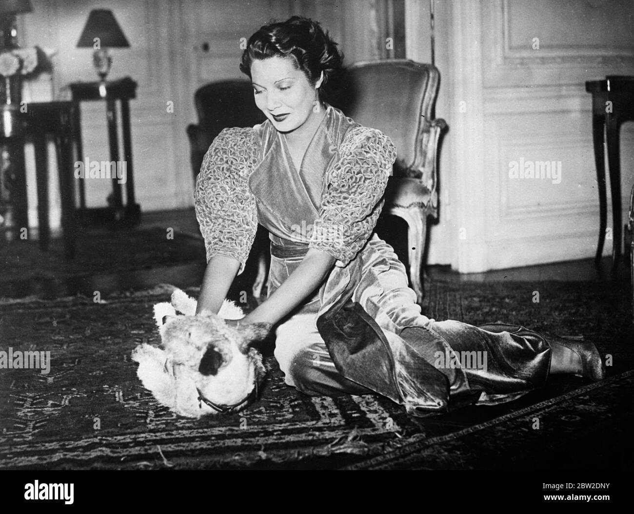 A 17-year-old girl, Mlle Jacqueline Janet, (pictured playing with her pet dog at her Paris flat) granddaughter of the famous savant Paul Janet, has been elected as miss France and will compete against international beauties for the title miss Europe at the end of this month 10 October 1937. Stock Photo
