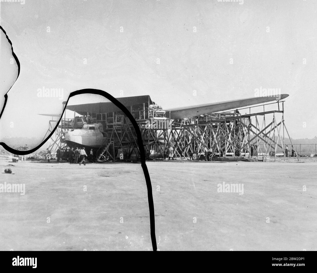 A huge Martin Clipper flying boat its 157 feet wing supported by trestles, under construction at the Martin works in Baltimore, Maryland for service in the Black Sea. The plane is 90 feet long and will have room for 26 people and a crew of seven powered by four 1000 hp engines the machine has a fuel capacity of 4000 gallons and cruising speed of 190 miles an hour it could make a transatlantic flight with ease. 10 October 1937. Stock Photo