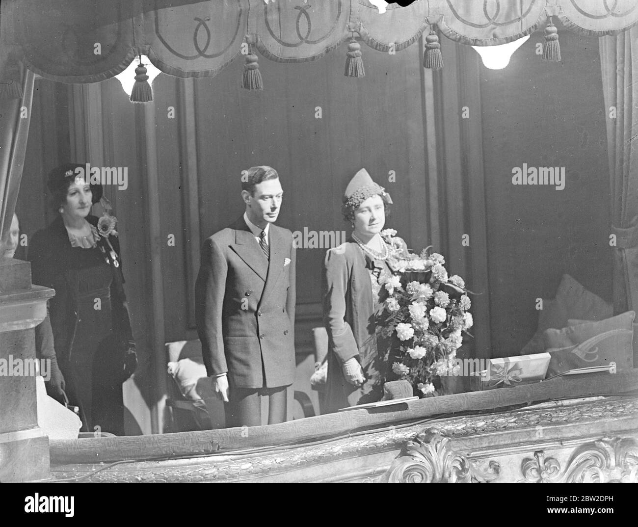 King and Queen at wounded ex-servicemen concert at Palladium. The King and Queen attended the Coronation Commemoration Concert for 3000 wounded ex-servicemen at the Palladium London. With them was Queen Ena (Victoria Eugenie of Spain). Photo shows, the King and Queen in the Royal box at the Palladium concert. 23 November 1937 Stock Photo