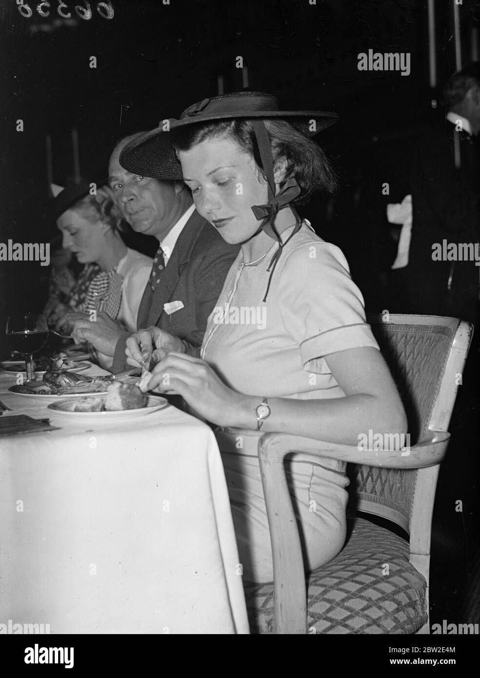 A flat hat tied with a bow under the chin worn by Miss EM Ascroat one of the guests at the luncheon given in connection with the Oxford group at Grosvenor house Park Lane London. 8 July 1937. Stock Photo