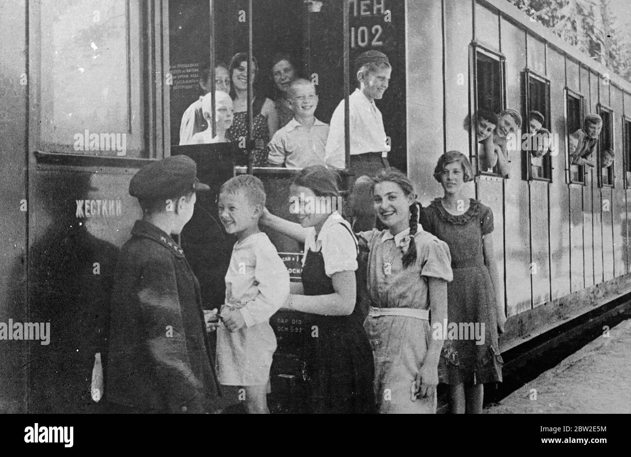 One of the poorly conductors checking tickets of charge passengers as they board the train. The only railway worked entirely by children is in service in the Soviet Union only 25 miles from Moscow. The children carry out all the duties on the railway, the miniature system serves a useful purpose for it makes youngsters familiar with railway technique. 25 July 1937 Stock Photo