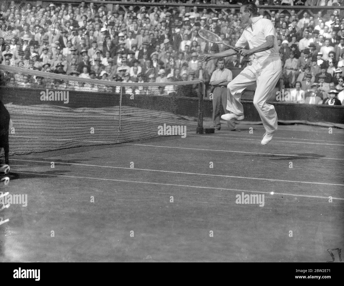 Hare leaps to take a shot during the match. Hare beat Budge to become Wimbledon champion winning 13-15 in their singles match in the Davis cup challenge round at Wimbledon. 24 July 1937 Stock Photo