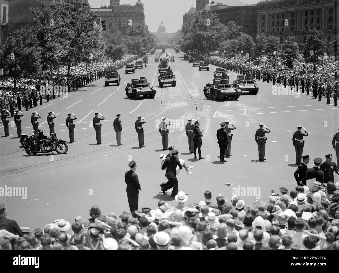 The Royal tour of Canada and the USA by King George VI and Queen Elizabeth , 1939 The King and Queen welcomed in Washington , the capital of the United States . The military procession passed up Pennsylvania Avenue on the way to the White House . The terrific heat caused hundreds people to collapse and a woman is carried away by police . Stock Photo
