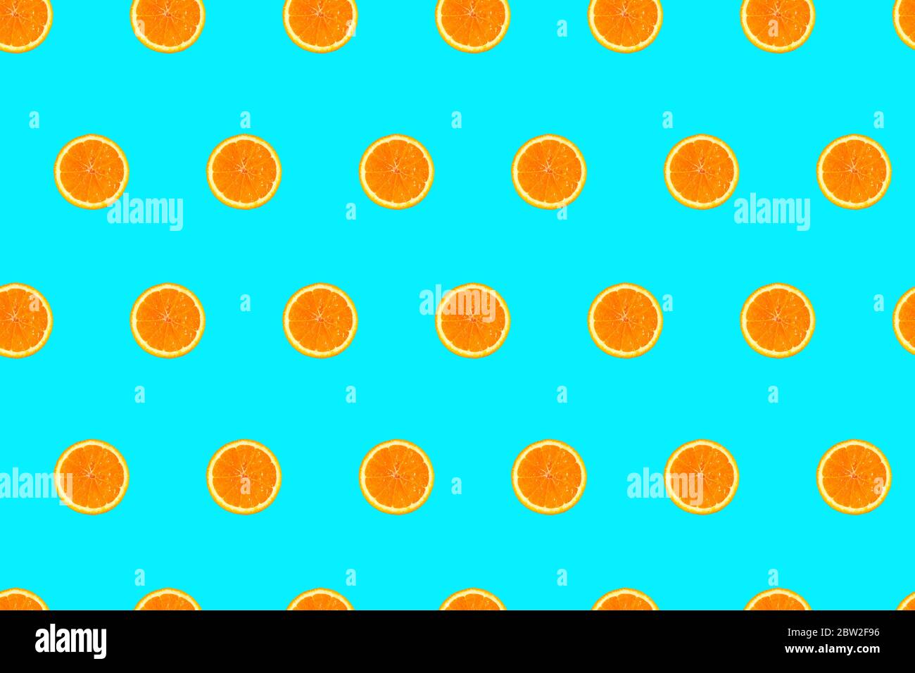 Orange halves on bright light blue background seamless pattern. Stock Photo