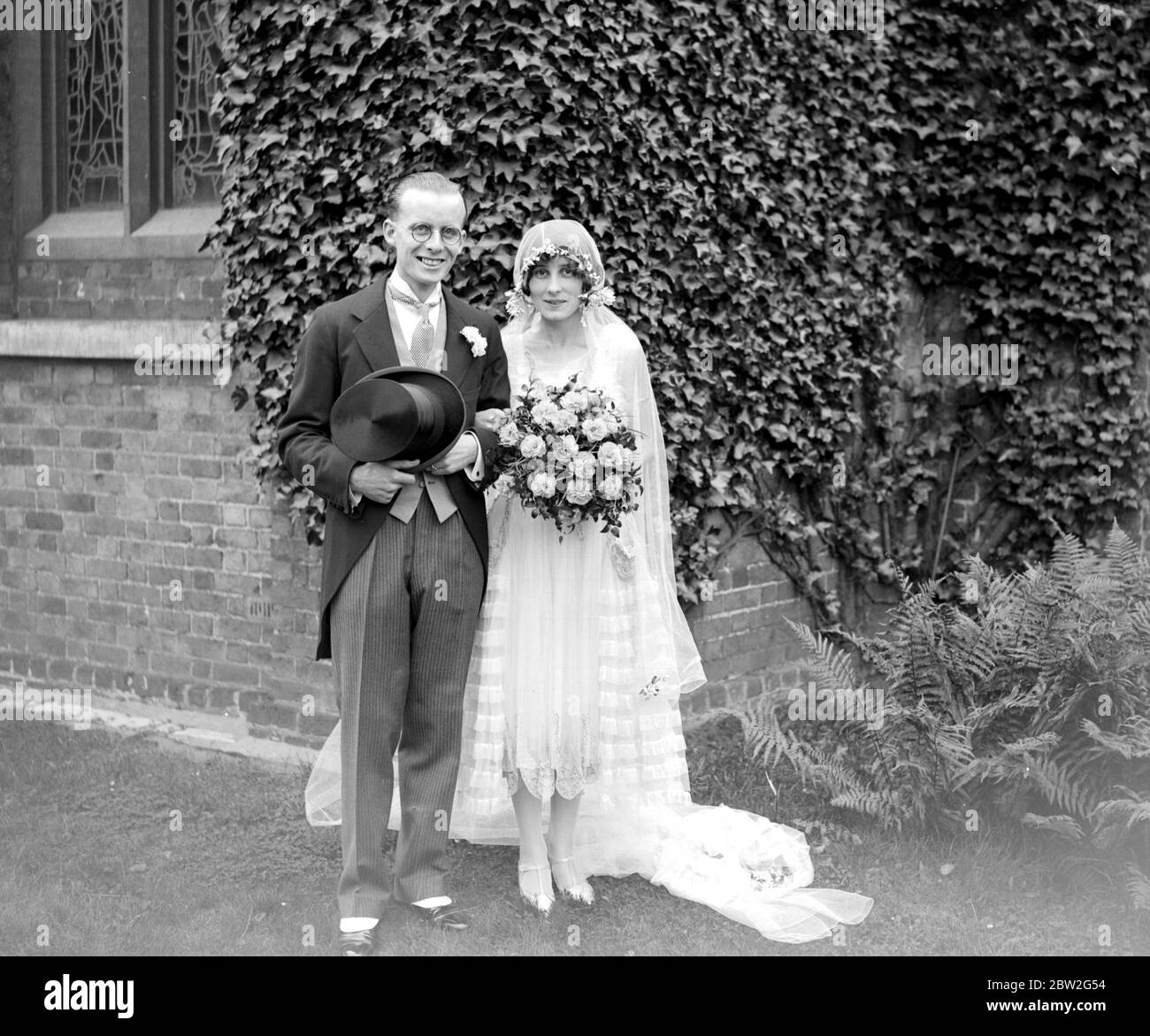 Mr Cecil J. Sainsbury and Miss Hilda Grace Plumridge (A cashier at the firm's new Malden Branch) after their wedding at St Andrew's Church, Totteridge. 11 September 1928 Stock Photo