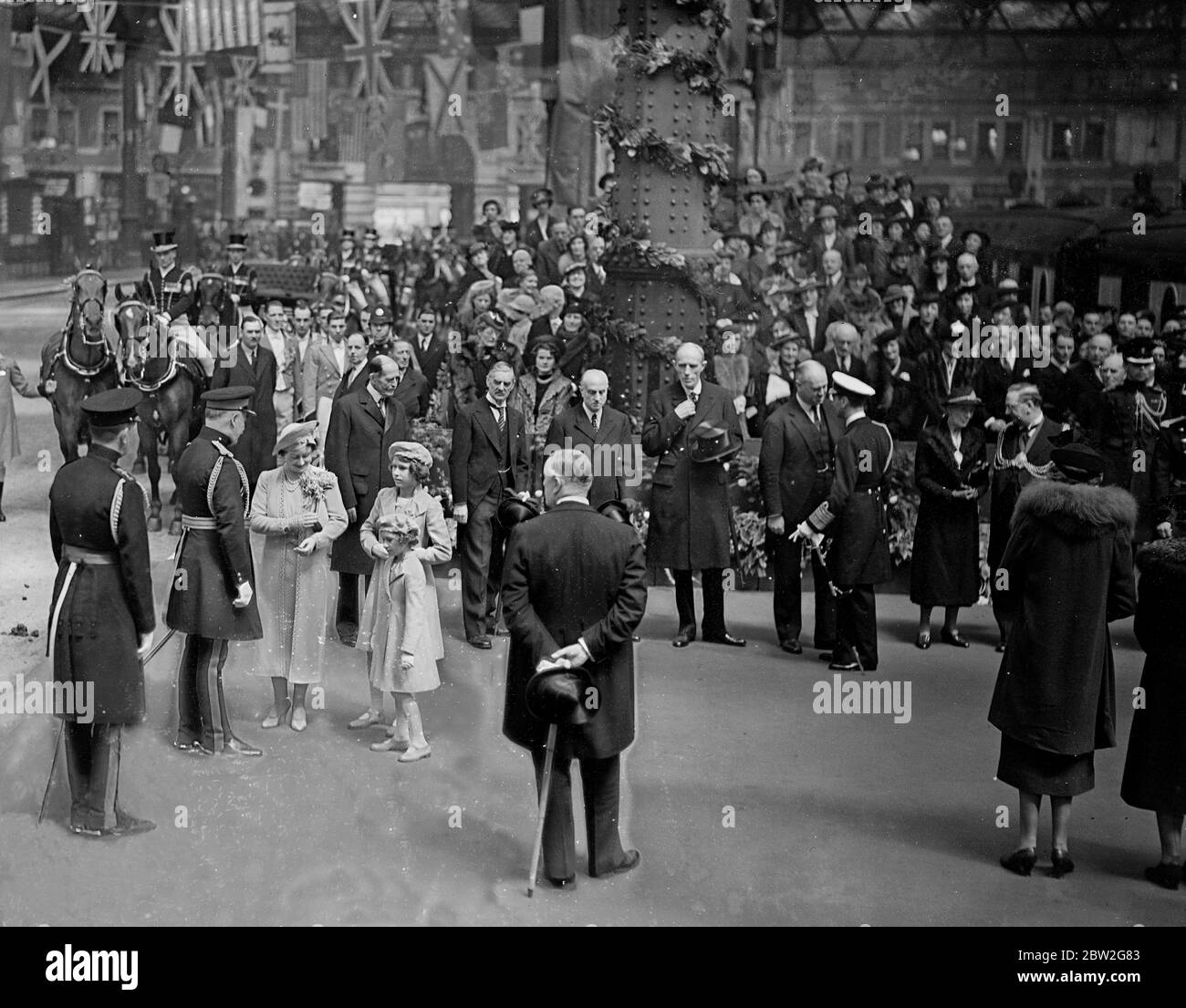 The Royal tour of Canada and the USA by King George VI and Queen Elizabeth , 1939 The Queen with the two Princesses saying goodbye at Waterloo Station . In the background is the King chatting to Lord Halifax , Sir Thomas Inskip, Sir Samuel Hoare and Mr Neville Chamberlain. Stock Photo