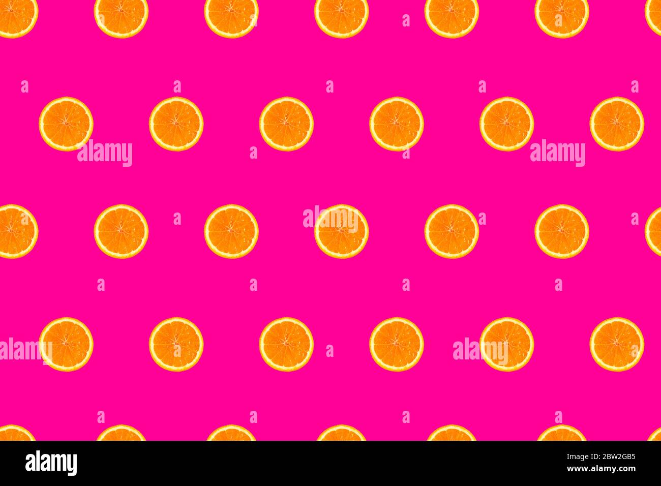 sliced oranges on bright pink background seamless pattern. Stock Photo