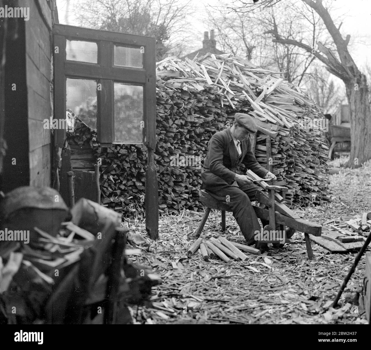 A Primitive Industry. One of the oldest industries in this country is carried on in the woods at High Wycombe, Bucks, whence for hundreds of years, chair legs, tent pegs, etc, have been made by hands, the trees being felled and split and turned without the aid of machinery. February 1934 Stock Photo