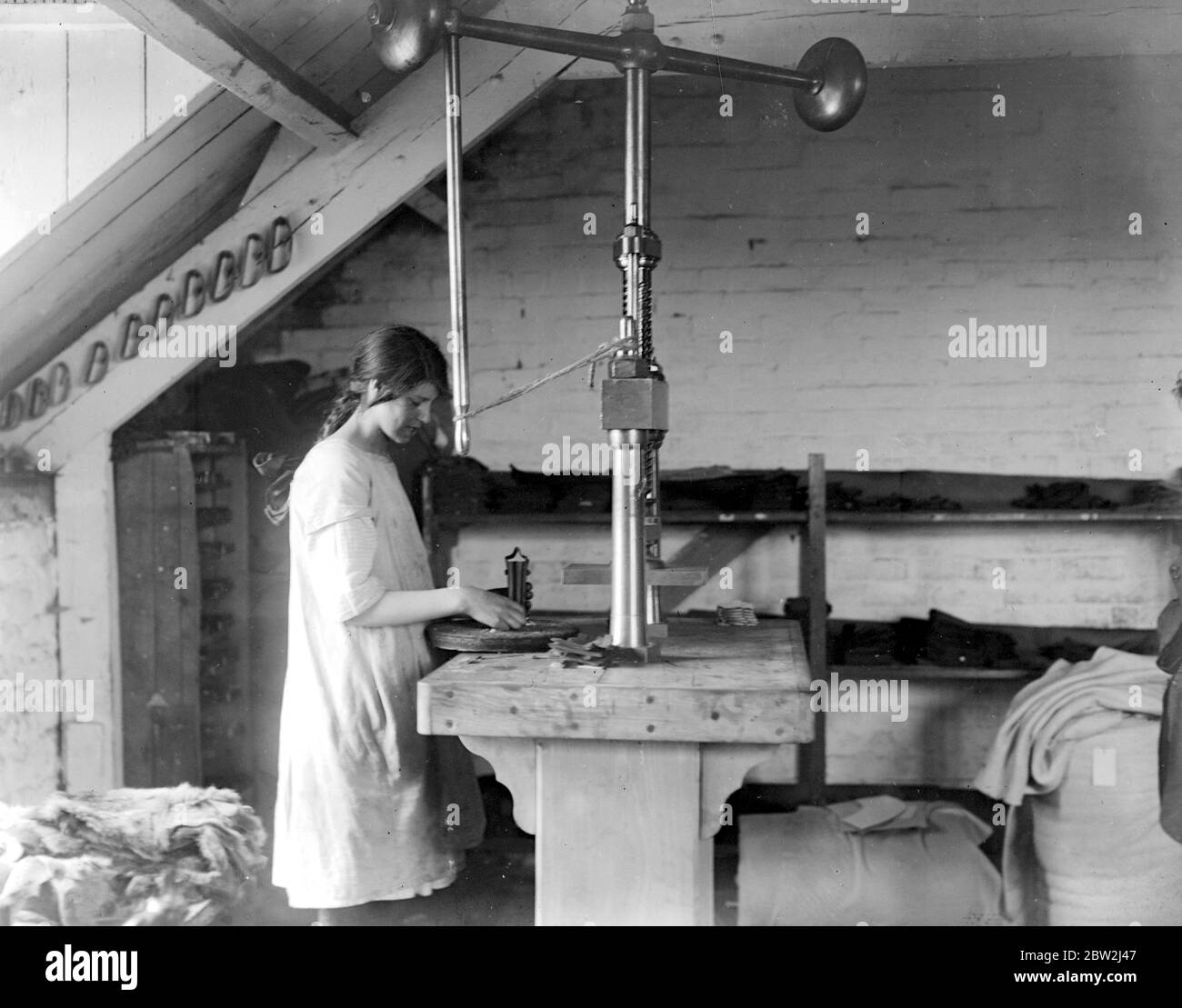 Glove Making At Witney . Press - used for the production of leather palms and fitting of leather for fur backed gloves . [no date] Stock Photo