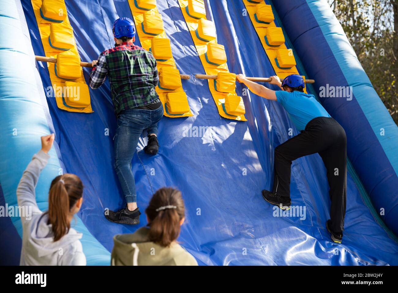 Group of enthusiastic men and women passing obstacles and having fun on ...