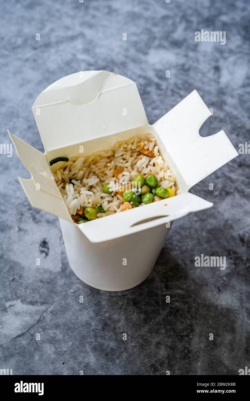 Take Out Chinese Rice with Green Peas and Almond in Plastic Box Package and Chopsticks / Street Food. Traditional Food. Stock Photo