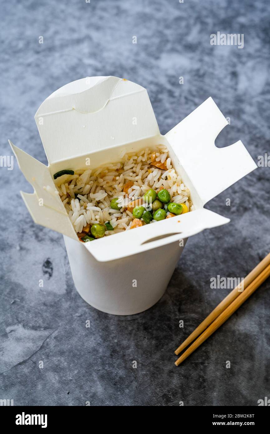 Take Out Chinese Rice with Green Peas and Almond in Plastic Box Package and Chopsticks / Street Food. Traditional Food. Stock Photo