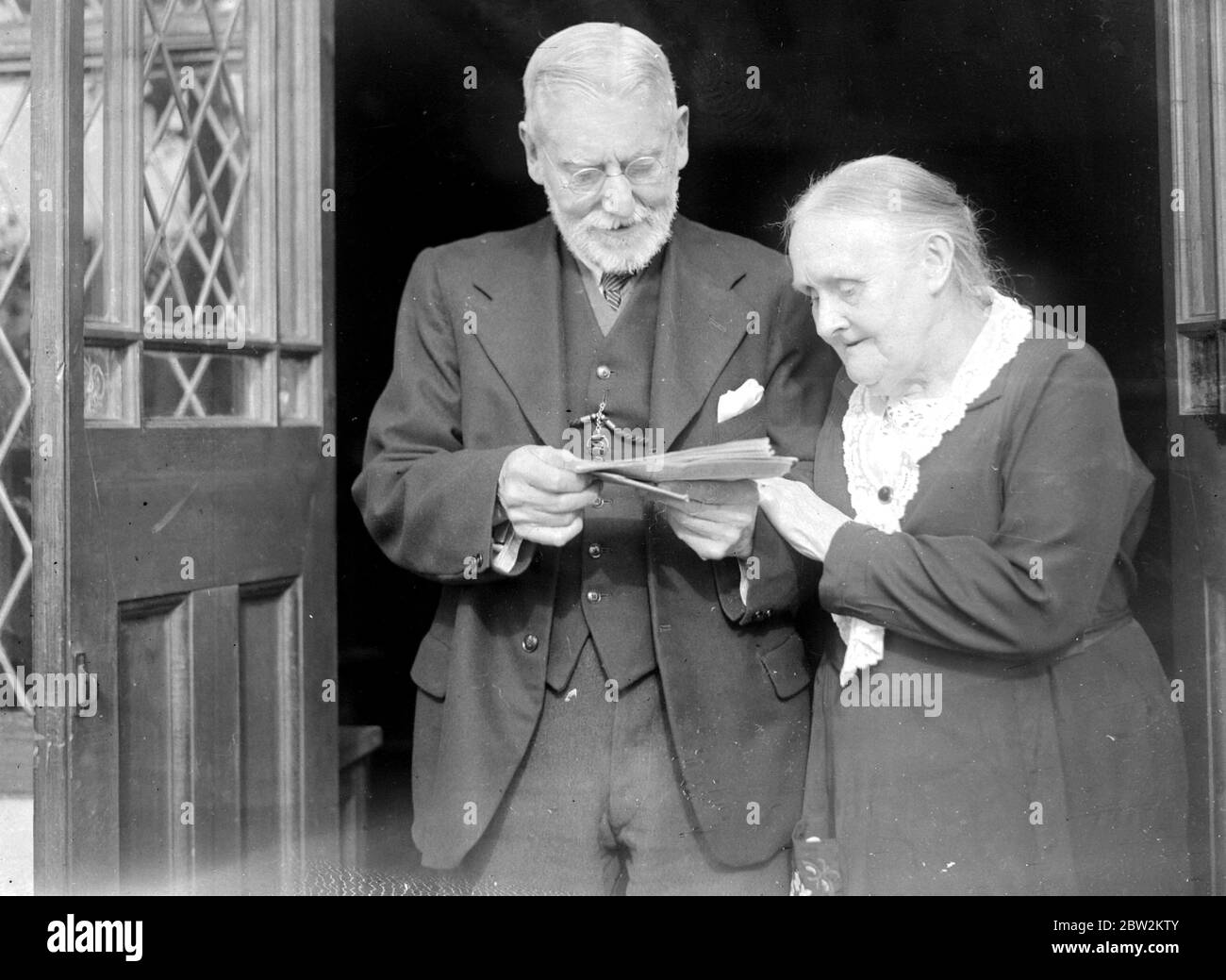 Mr and Mrs Harber at their Diamond Wedding reading a telegram. 1934 Stock Photo