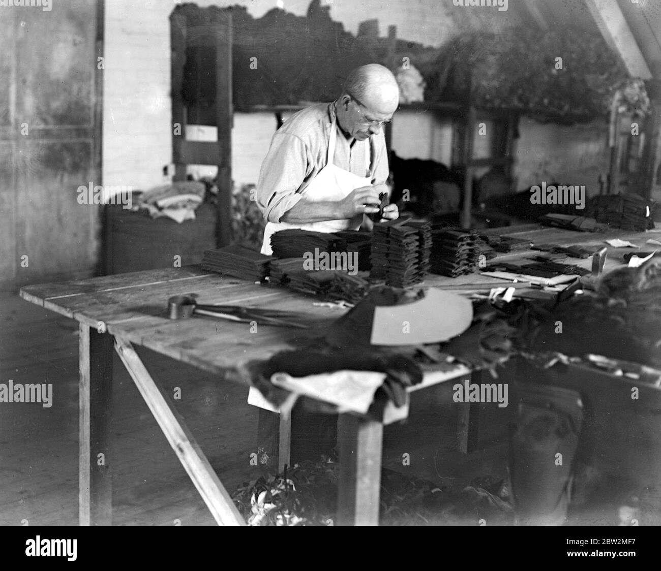 Glove Making At Witney . The foreman , who is seen preparing and selecting fittings of all varieties , palms , lining , etc . [no date] Stock Photo