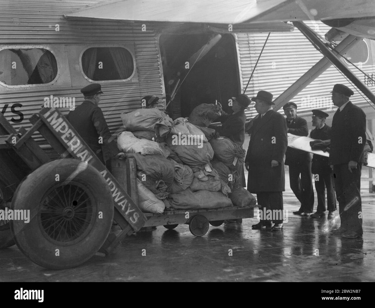 First Cape to London Air mail arrives at Croydon . The first Cape to London air mail arrived at Croydon , nine days late . The machine was held up in South Africa when it made a forced landing . Unloading the mails on arrival at Croydon Aerodrome . 16 February 1932 Stock Photo