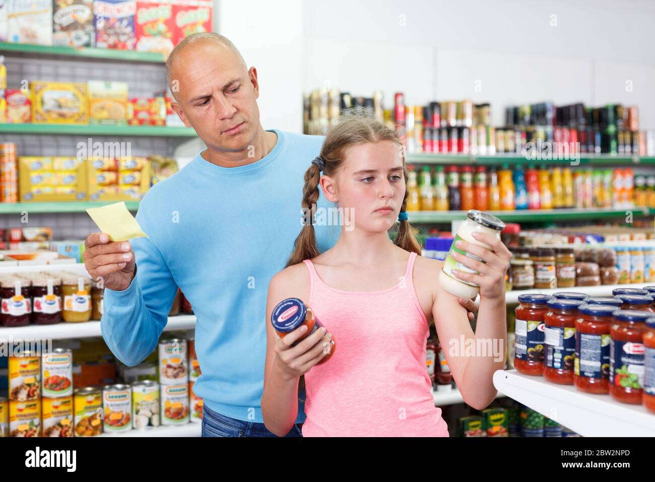 Family of man and tween daughter selecting  food at grocery store Stock Photo