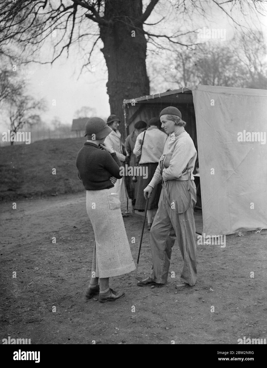 Waterproof trousers at women 's golf tournament . The Ladies Golf Union International Tournament opened in rain at the Ranelagh Club , Barnes . Miss Ann de Montmorency wearing waterproof trousers . With her is Miss I B Dunand . 11 April 1934 Stock Photo