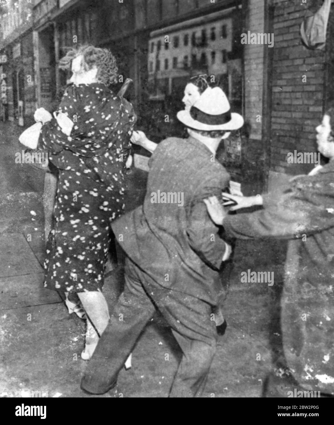 Original caption - The female of the species . Strike breakers roughly handled at Memphis . Girl strikers at the Tri State Manufacturing Company ' s factory in Memphis , Tennassee , proved that the female of the species is more deadly than the male when fellow workers tried to break the strike . One girl had her clothes ripped practically off and a luckless male was scratched and clawed about the face . Photo shows , girl pickets scratching and clawing a man and a woman who attempted to enter the factory at Memphis , Tennessee . 15 March 1937 Stock Photo