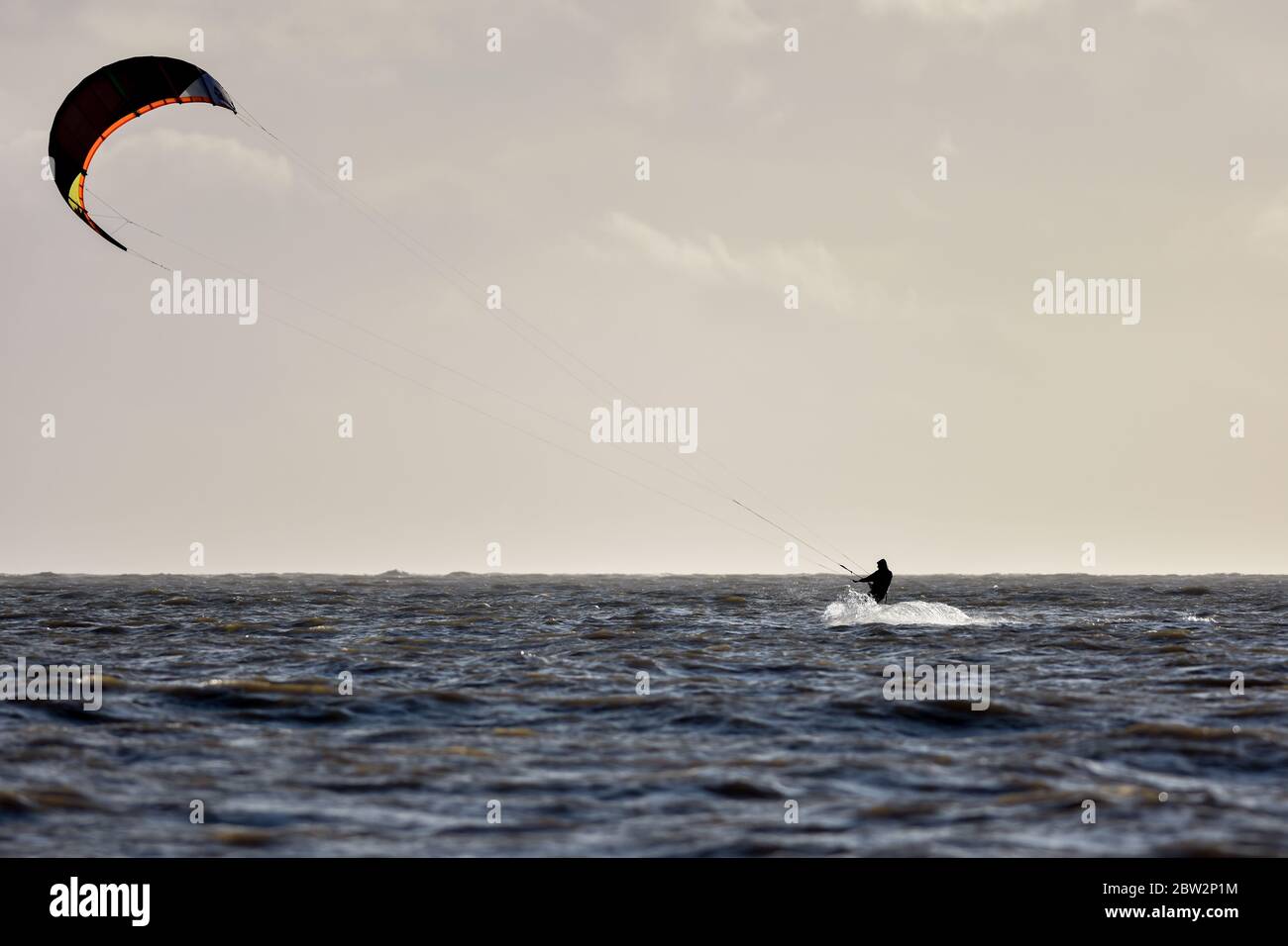 Wide shot of kitesurfer showing the the surfer and the kite Stock Photo