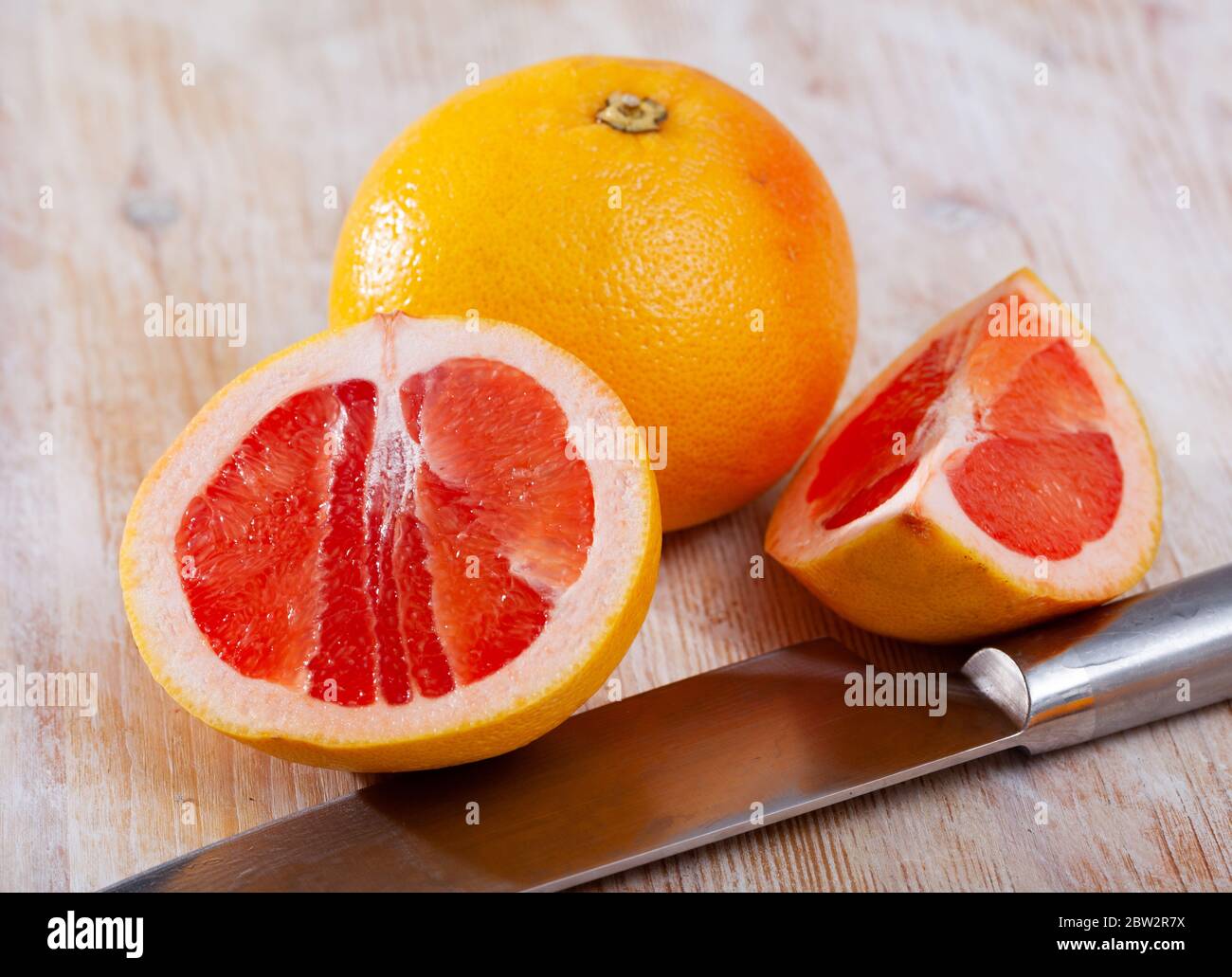 Sliced fresh juicy pink pomelo on wooden table. Concept of health