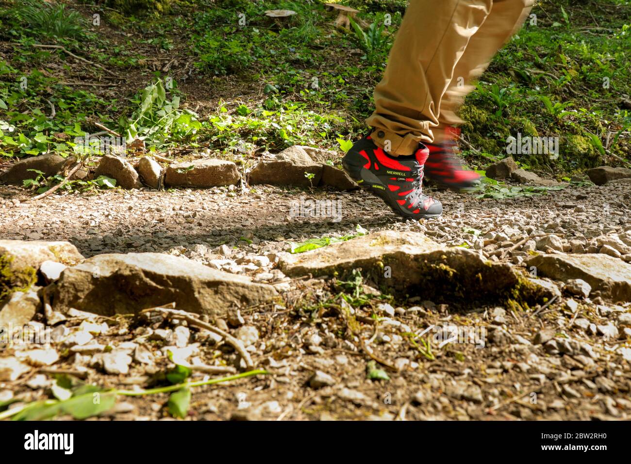 Man legs walking outdoor with a pair of Merrell Red Accentor Sport GORE-TEX  Trail Shoes Stock Photo - Alamy