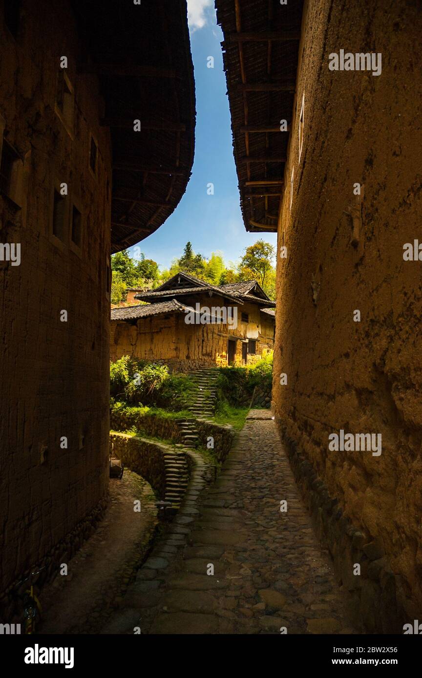 View of a tulou between the gap of two other earth buildings in Gaobei Cluster, Yongding County, Fujian Stock Photo