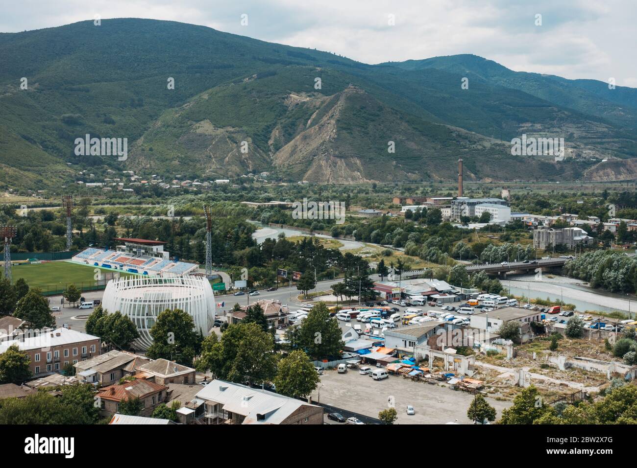 Looking out over the city of Gori, in eastern Georgia. The circular structure bottom left is the Gori Public Service Hall Stock Photo