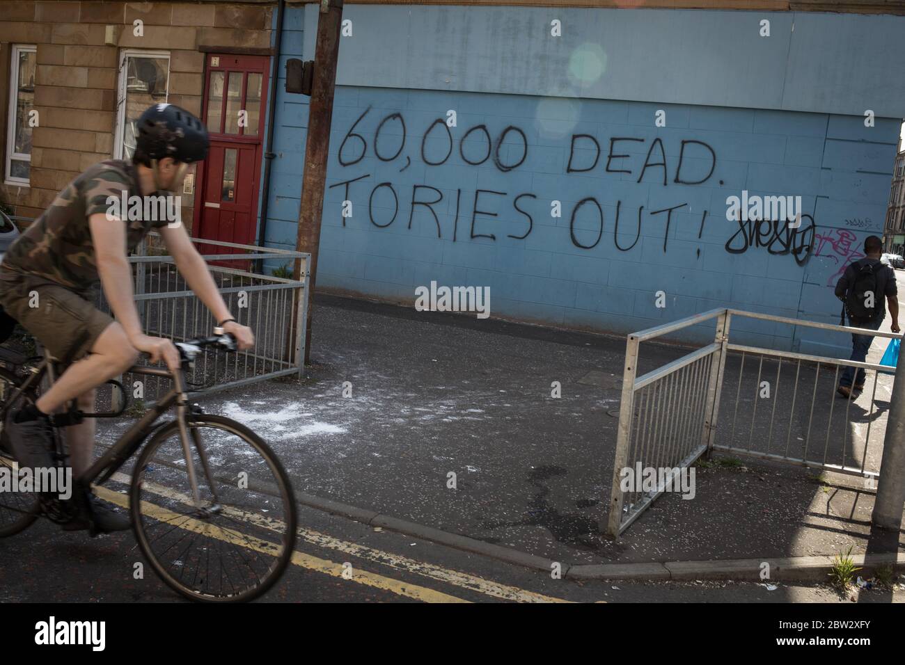 Glasgow, UK, 29th May 2020. Graffiti reading '60,000 Dead, Tories Out!'  has appeared on a wall in the Govanhill district of the city, displaying local anger at the policies and handling of the CoronaVirus Covid-19 health pandemic by the UK's Conservative government led by Prime Minister Boris Johnson. In Glasgow, Scotland, on 29 May 2020. Photo credit: Jeremy Sutton-Hibbert/Alamy Live News. Stock Photo