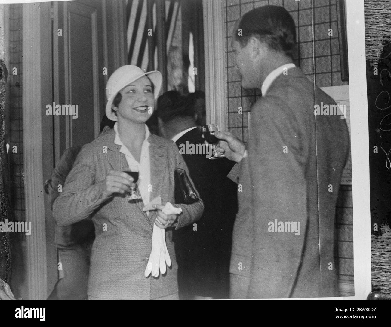 Helen Wills drinks a toast . Mrs Helen Wills Moody , the American tennis ' Queen ' who is a regular spectator at the Davis Cup matches in Paris , drinking a toast with Mr Lawrence Baker of the American Davis Cup Committee in Paris . Mrs Helen Wills Moody drinking the toast with Mr Lawrence Brady . 30 July 1932 Stock Photo