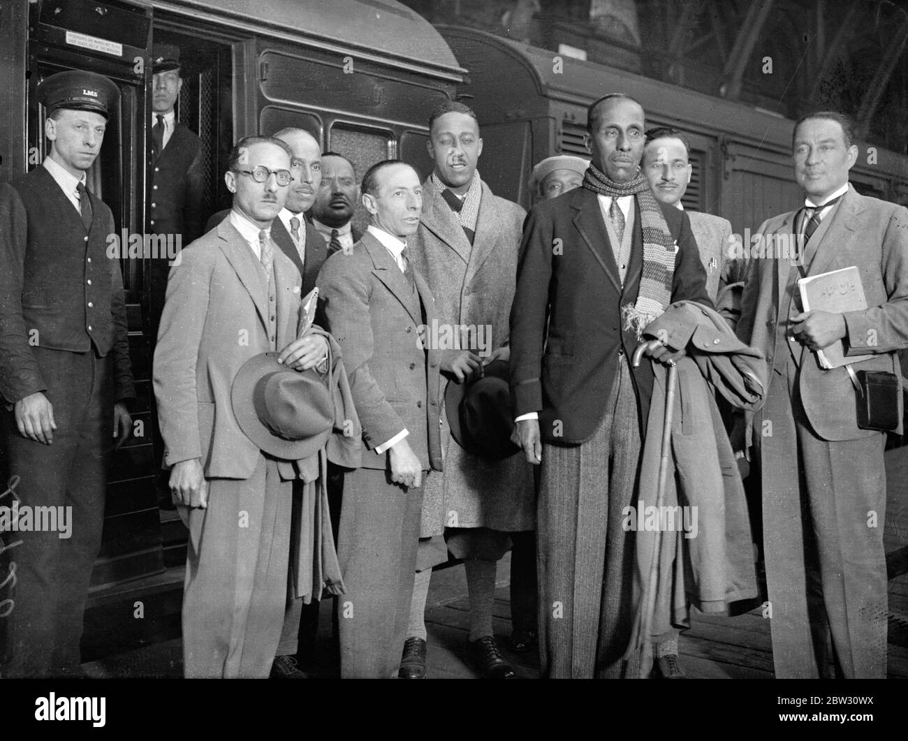 Moroccan Prince arrives in London . El Glaoui , the Passha of Marrakesh , in Morocco , who is known as Sultan of the Atlas , arrived in London to spend fifty days in England . El Glaoui is a keen golfer and has a golf course and professional of his own on his estates in Marrakesh . El Glaoui ( wearing scarf ) with members of his party on arrival at St Pancras sttaion , London . 4 August 1932 Stock Photo
