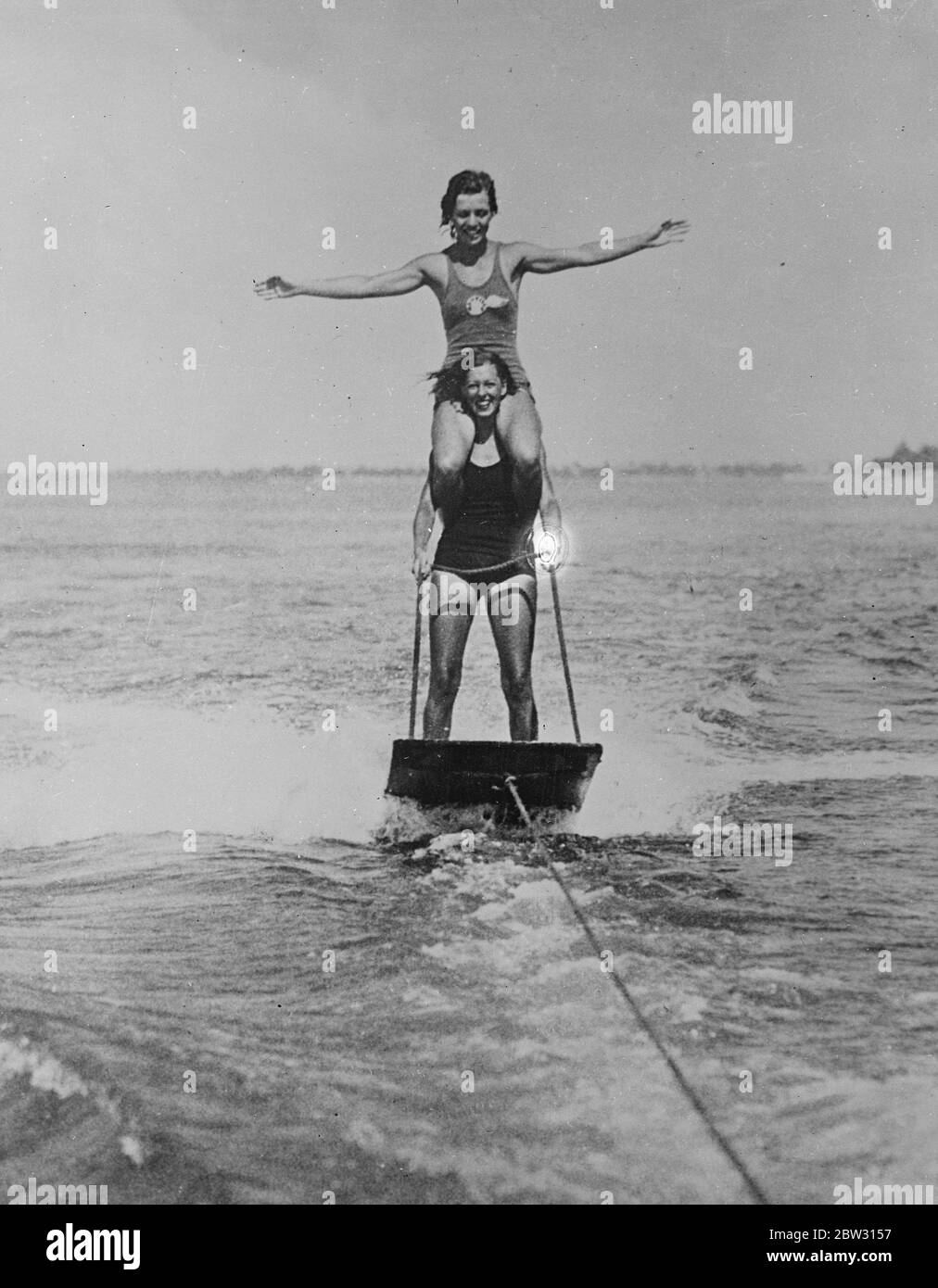 Aquaplaning with a passenger aboard . Helen Daly , carrying Betty Baily , on her shoulders during a daring aquaplaning stunt at Miami , Florida . 1 March 1932 Stock Photo