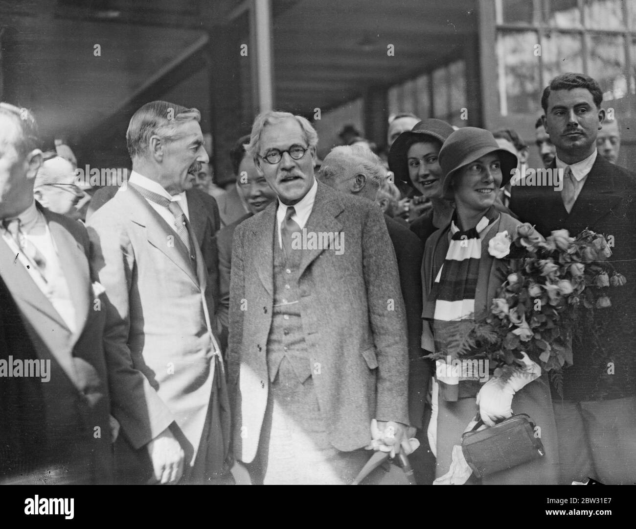 Mr Ramsay MacDonald receives great welcome home from reparations conference . Mr Ramsay MacDonal , the Premier , received a great welcome at Victoria Station , London , when he arrived home from Lausanne after his great work in securing the success of the Lausanne Reparations Conference . He was met by Sir Clive Wigram private secretary to the King , and members of the Cabinet . Mr Ramsay Macdonald with his daughter Ishbel and Mr Neville Chamberlin on arrival at Victoria station , London . 10 July 1932 Stock Photo