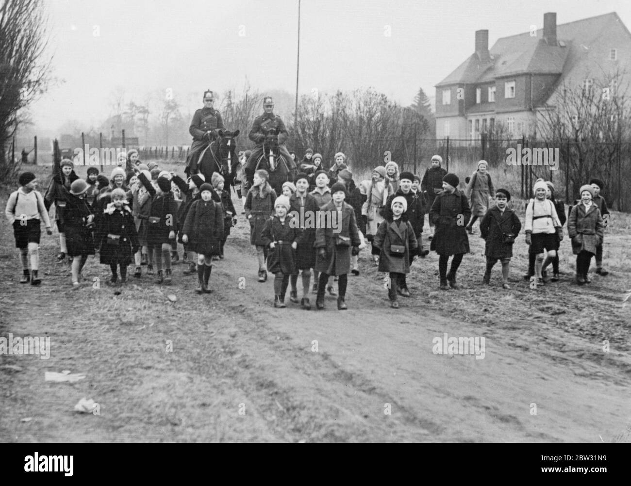German police escort children to school following kidnapping scare in Berlin suburb . Following the disappearance of a schoolgirl from the Zehlendorf suburb of Berlin , police are escorting the schoolchildren to and from their schools , while a close watch is kept on them while at play in the fields . Police escorting German schoolchildren to school in the Zehlendorf suburb of Berlin . 10 March 1932 Stock Photo