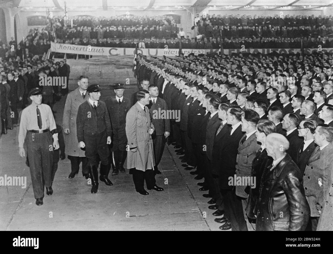Hitler reviews his shock troops in Berlin . Adolf Hitler , the German Fascist leader who hopes to rule Germany , reviewing his shock troops in Berlin sports palace , for the purpose of giving them instructions for the forthcoming German General election . 11 February 1932 Stock Photo