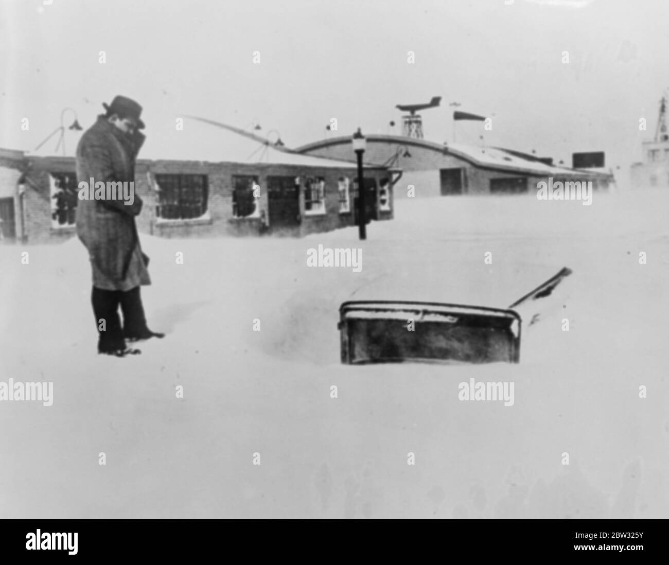 Buildings buried in grat snowstorm in America . Whole buildings at Buffalo , New York , were almost buried beneath snow drifts in a great snow storm which paralysed the city . Cars were buried beneath . A car buried in the snow which in some places was more than twelve feet deep . 18 March 1932 Stock Photo