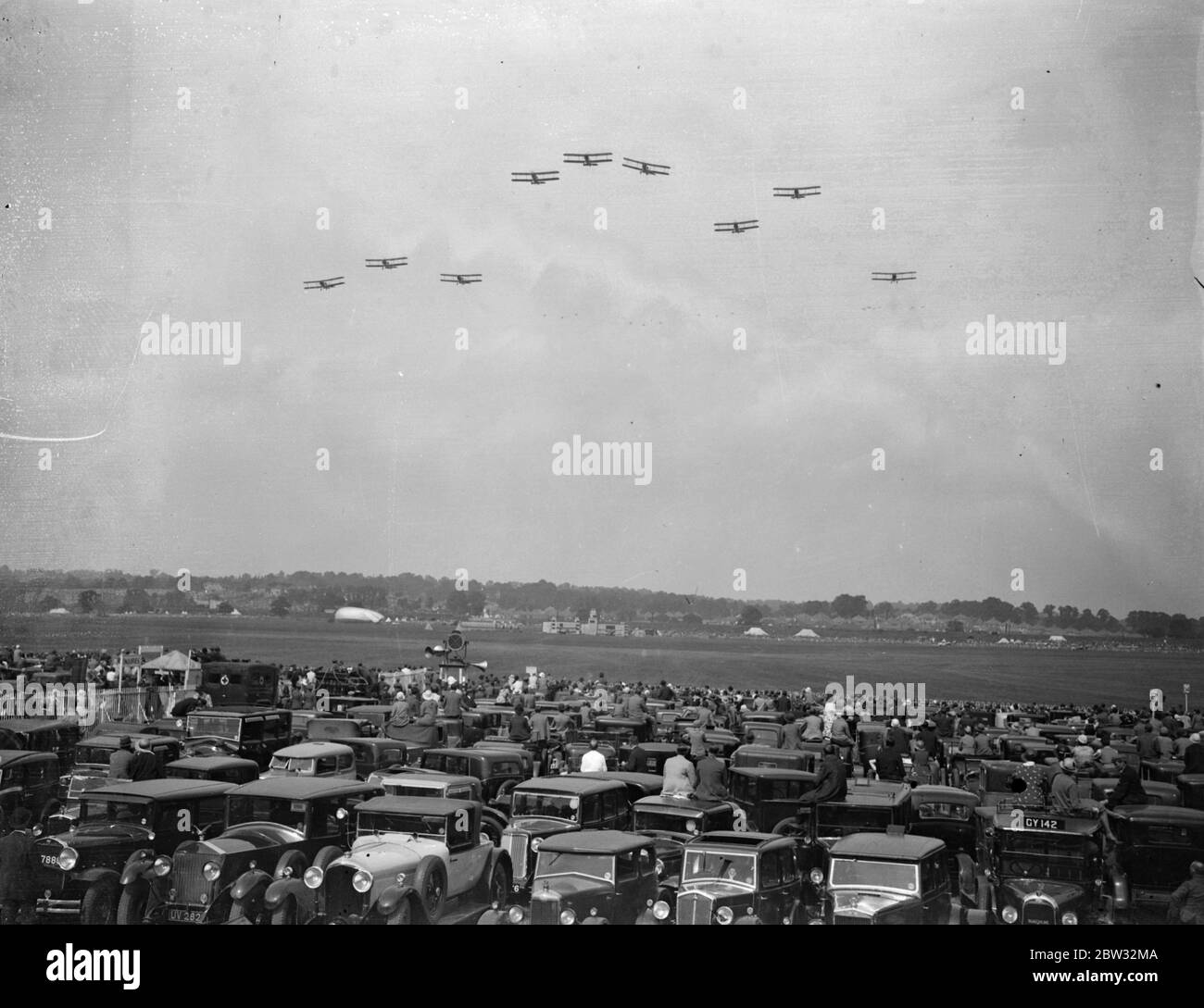Enormous crowd watches thrilling air display at Hendon Air Pageant . An enormous crowd watched thrilling display of flying and aerial acrobatics at the Hendon Air Pageant , by the Royal Air Force , at Hendon Aerodrome , London . Planes flying over the crowd at Hendon . 25 June 1932 Stock Photo