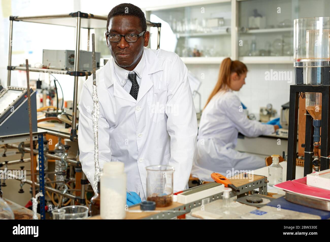 Serious man lab scientist in glasses working with reagents and test ...
